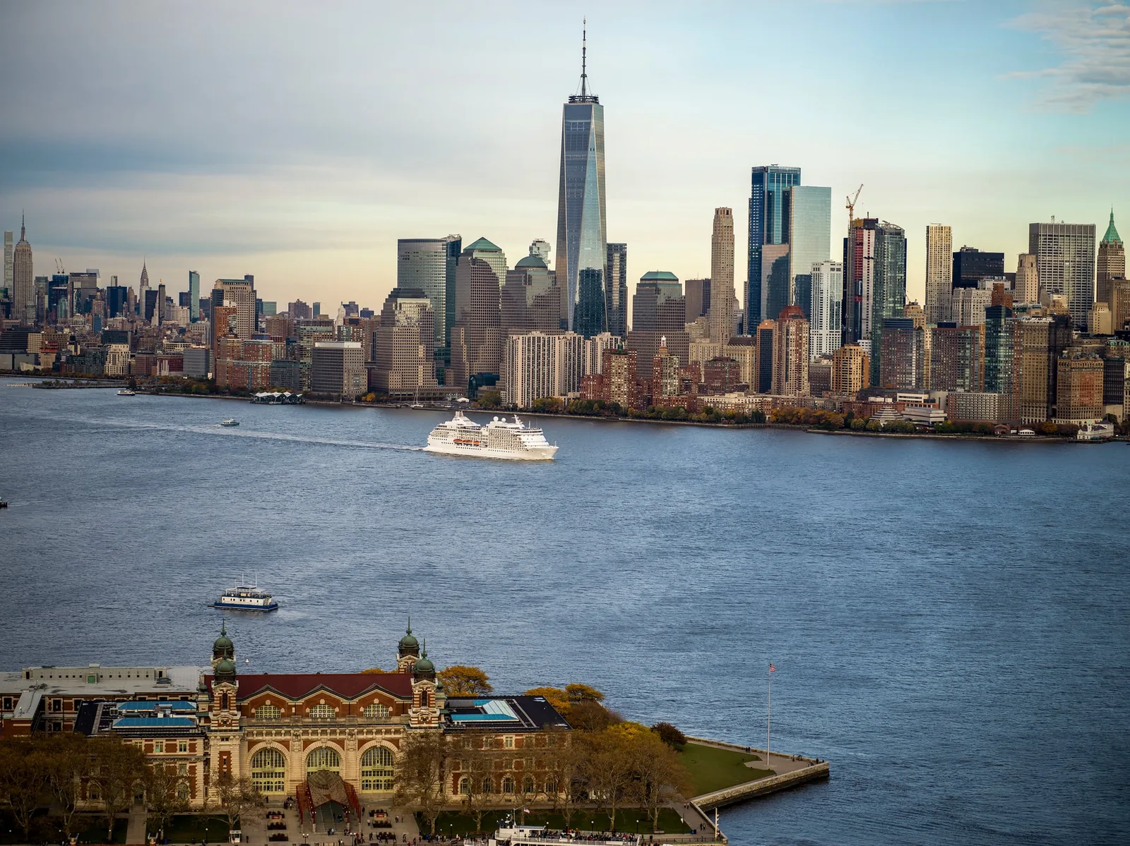 Kreuzfahrtschiff vor der Skyline von New York bei Sonnenuntergang