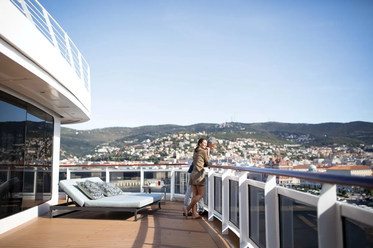 Paar auf der privaten Terrasse einer Regent Suite mit Blick auf die Küste