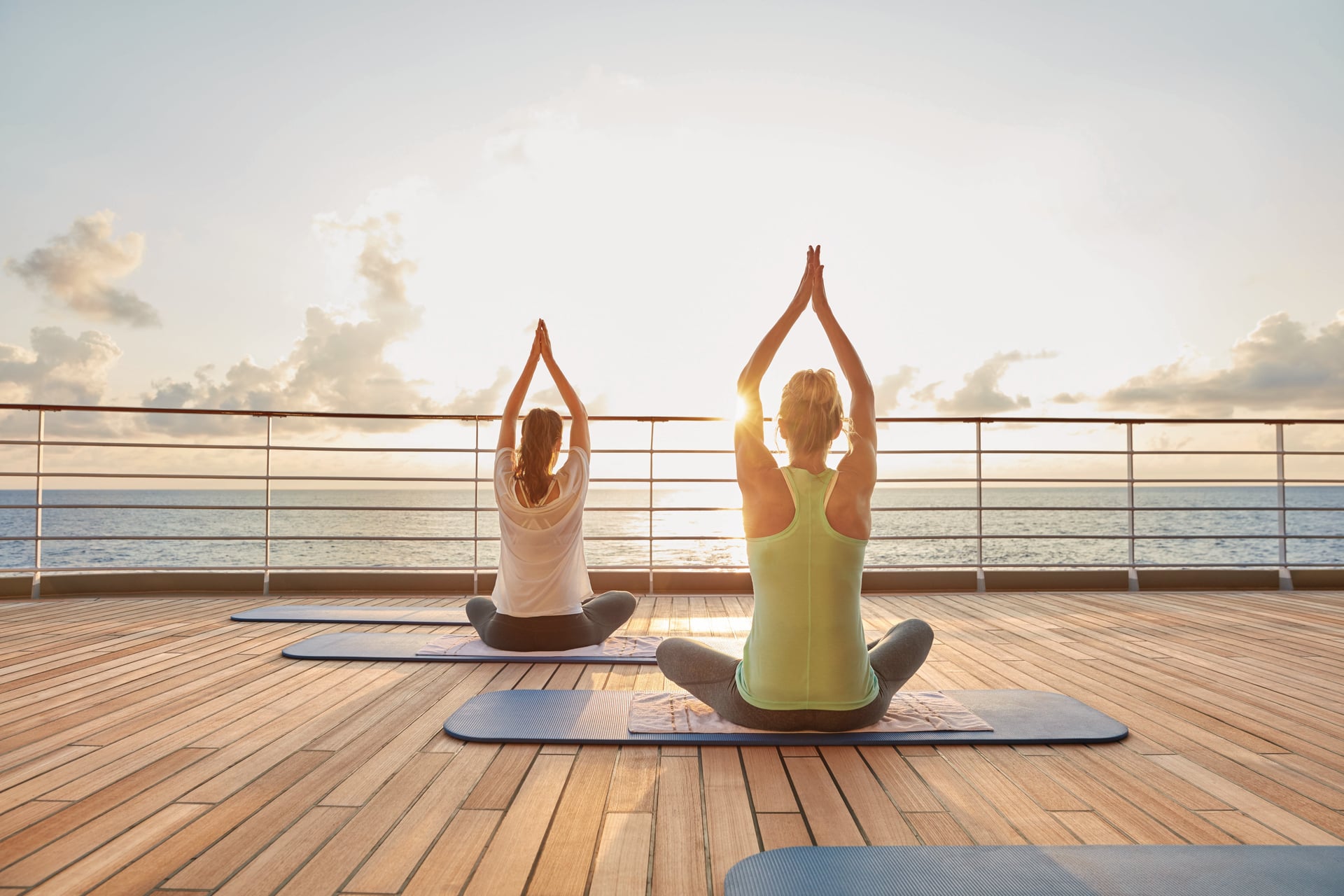 Yoga an Deck eines Hapag-Lloyd Kreuzfahrtschiffs bei Sonnenaufgang