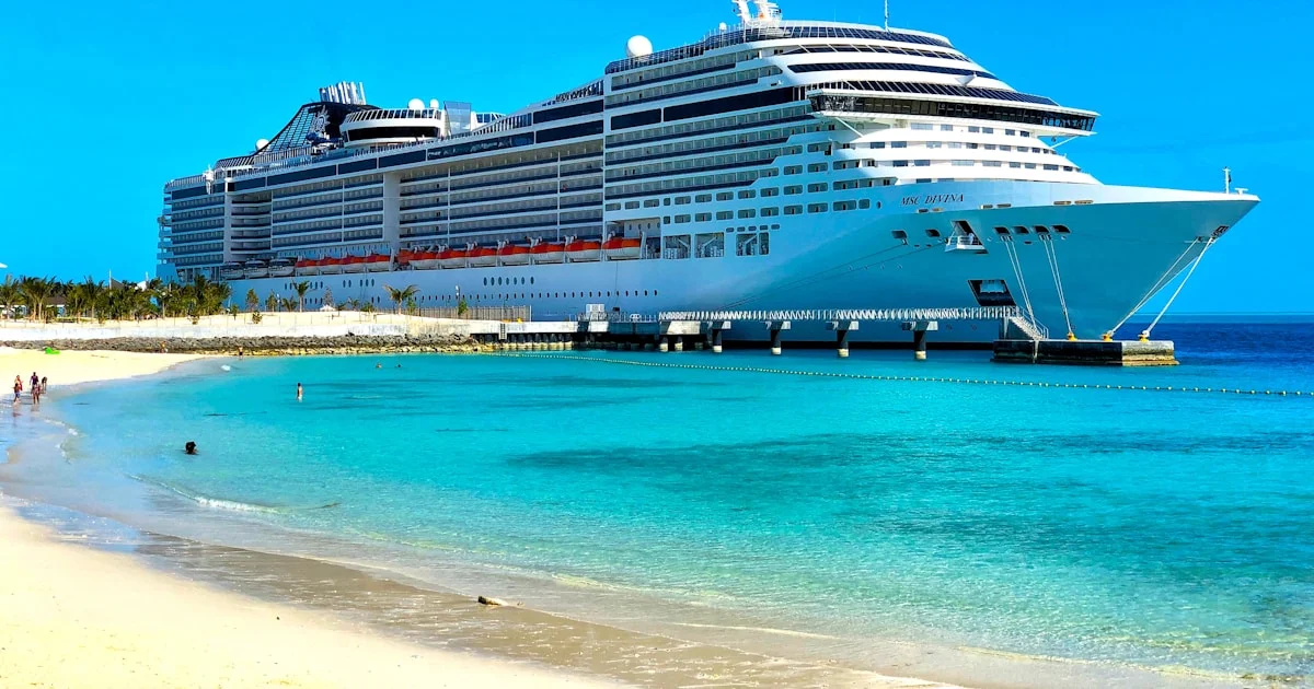 Karibik-Kreuzfahrt – Schiff vor türkisfarbenem Wasser und Palmenstrand