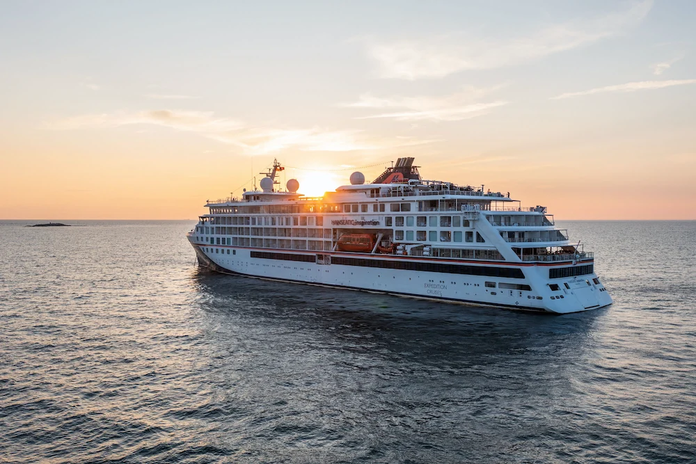 HANSEATIC-Expeditionsschiff im warmen Abendlicht auf See