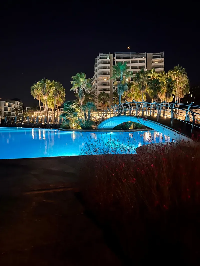 Lara Barut Collection: Poolanlage und Hotelgebäude bei Nacht.