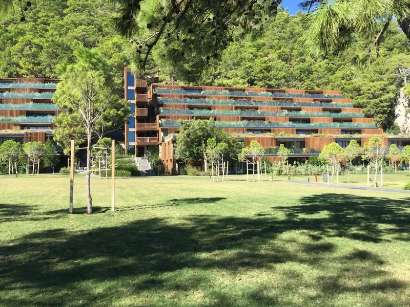Maxx Royal Kemer: Hotelgebäude mit Holzfassade und Garten.