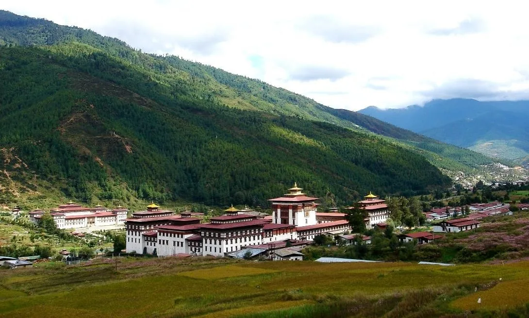 Blick über das grüne Paro-Tal mit traditioneller Dzong-Architektur
