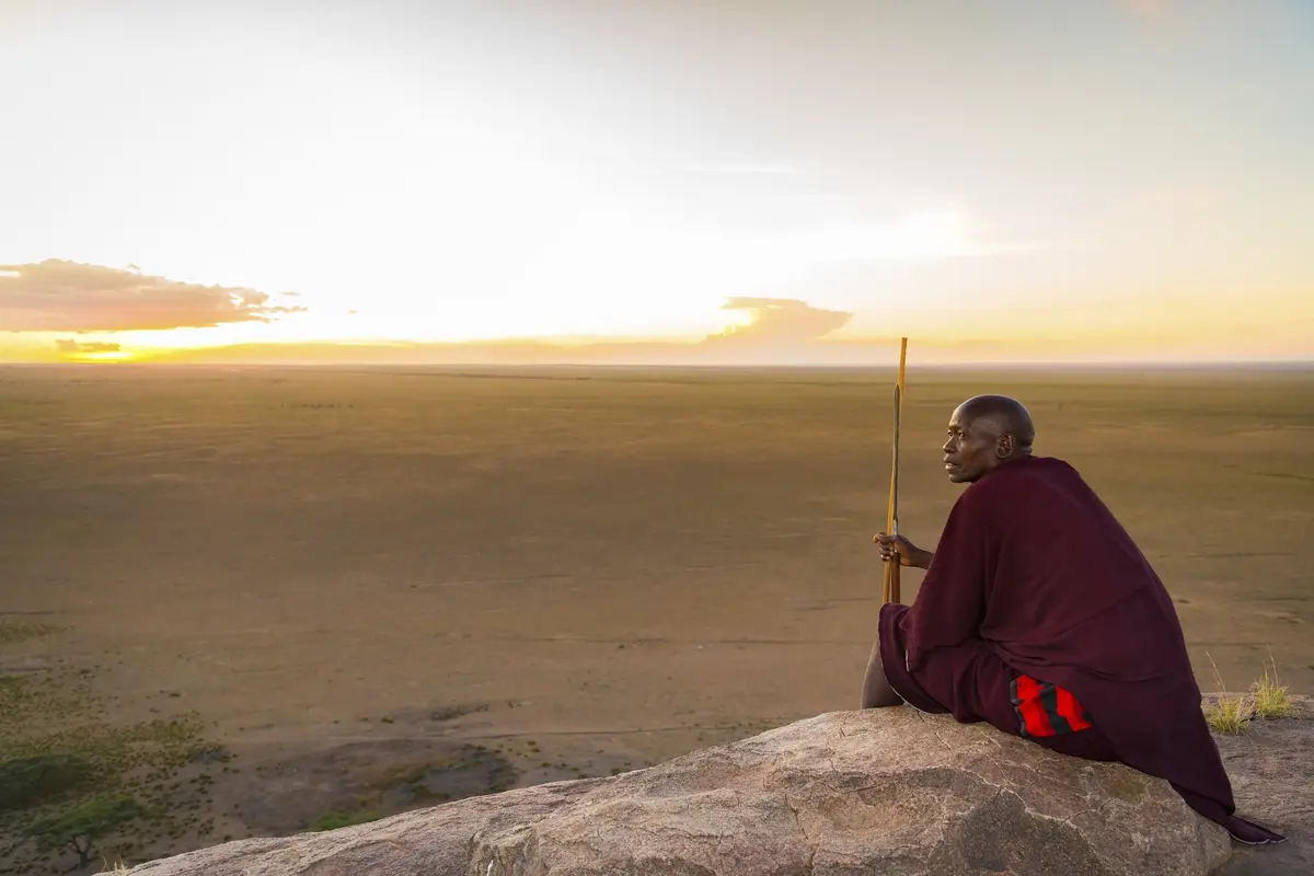 Massai auf einem Felsen bei Olduvai im Licht des Sonnenuntergangs