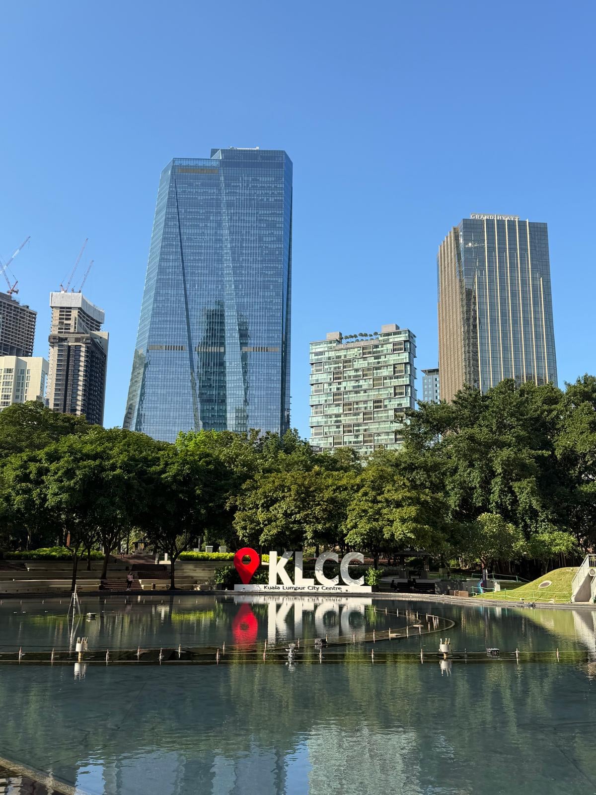 Stadtpark mit moderner Skyline und Wasser