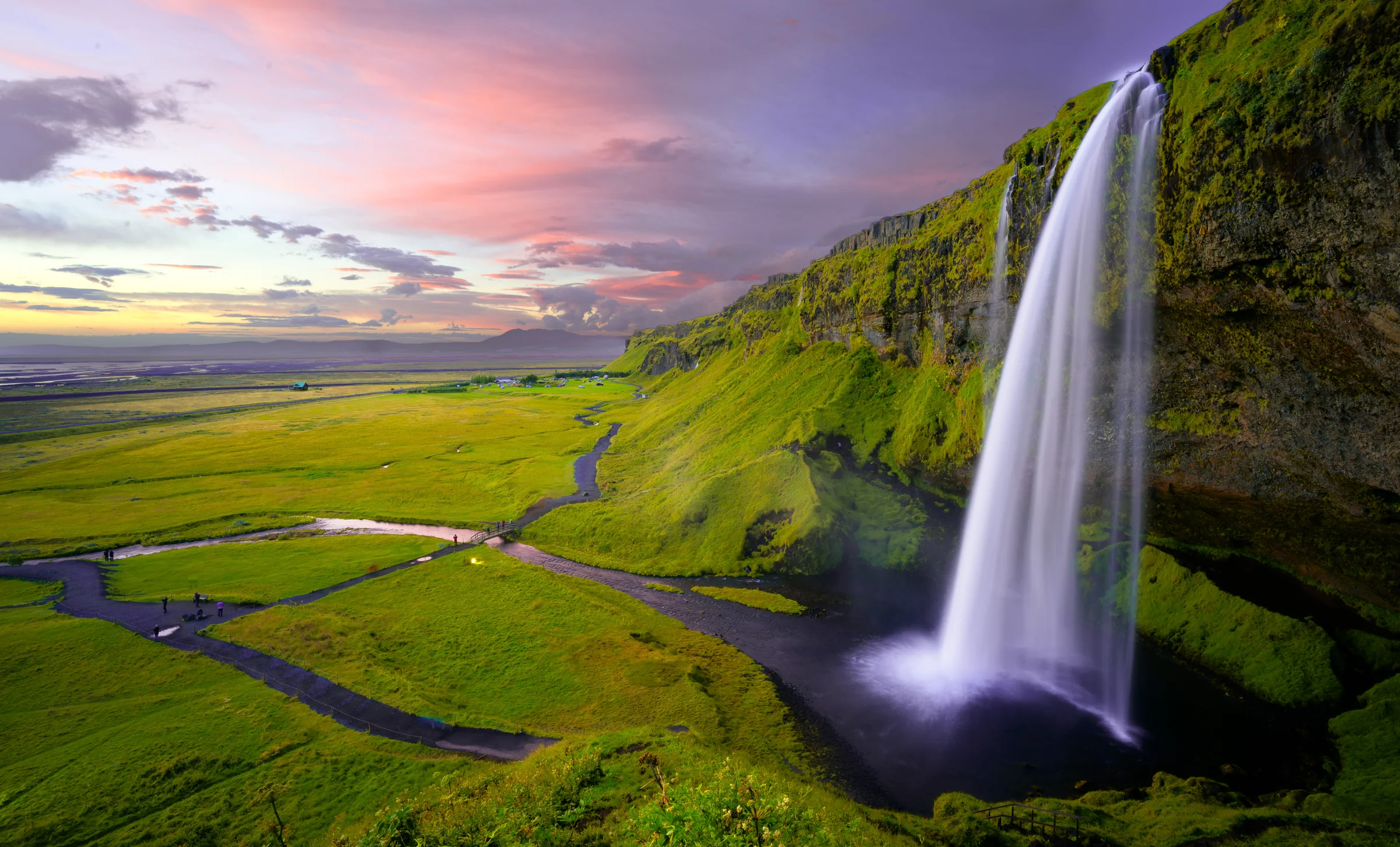 Grüne Landschaft und Wasserfall auf Island