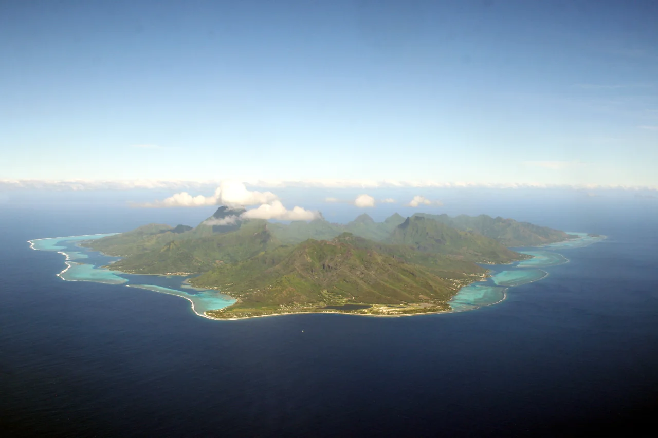 Moorea mit grünen Bergspitzen und türkisfarbener Lagune aus der Luft