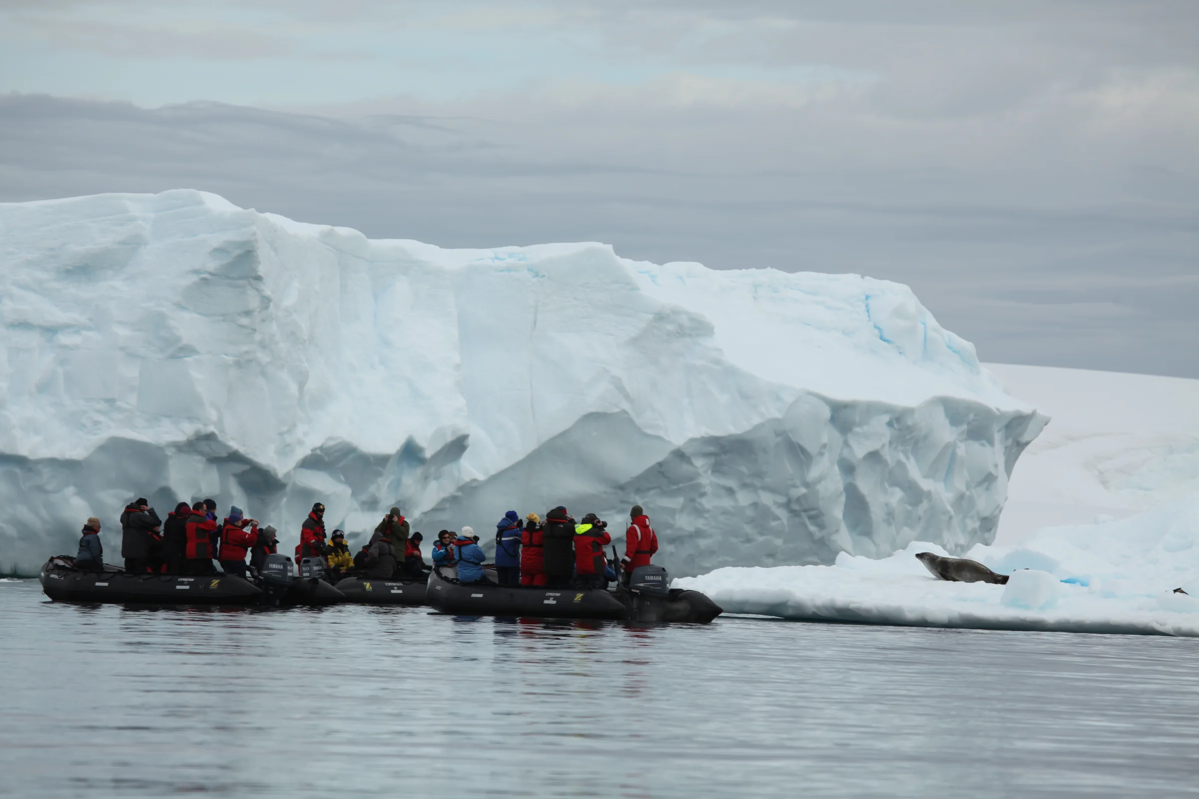 Expeditionsgäste im Zodiac zwischen Eisbergen in der Pléneau Bay